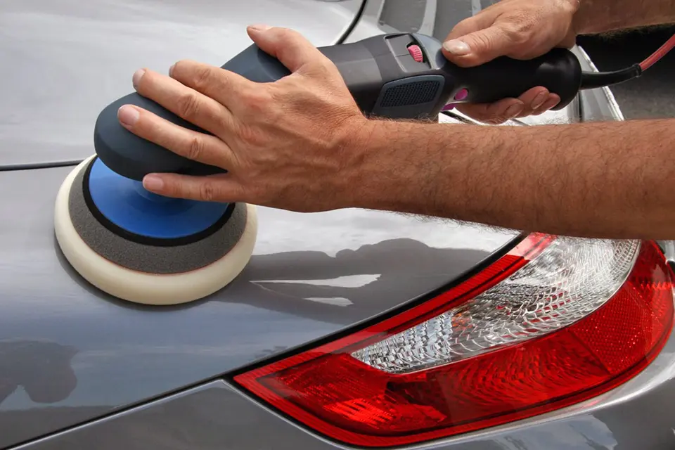 Politur mit der Poliermaschine an einem Fahrzeugheck